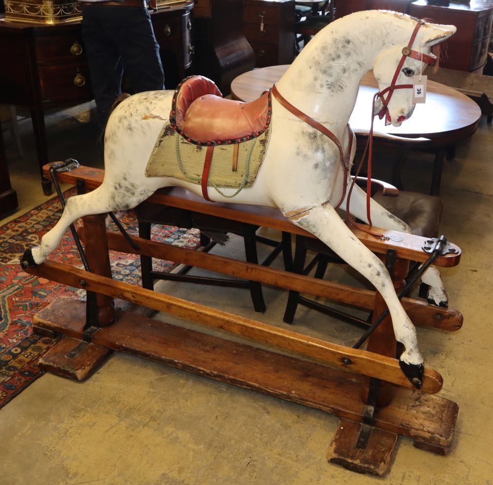 An early 20th century Ayres type carved wood dapple grey rocking horse on pine safety frame, H.130cm, L.160cm